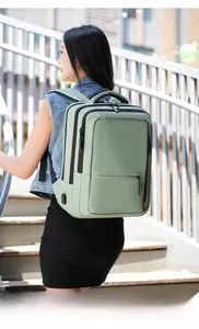 Detailed view of light green laptop backpack with external USB port on an outdoor model