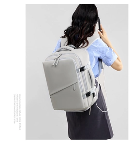Detailansicht des USB-Ladeanschlusses an der Seite eines hellgrauen Business-Rucksacks
