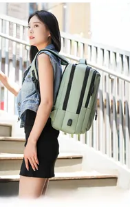 Detail showing the external USB charging port and zipper on the mint green laptop backpack