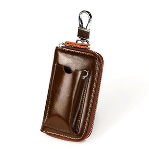 Detail of dark brown glossy leather key case with metal hook and card slot feature