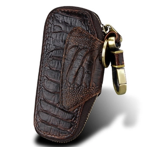 Detail of dark brown crocodile embossed leather car key case with golden metal hook