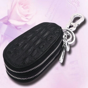 Detail of black crocodile embossed leather key case with dual zippers and metal hook