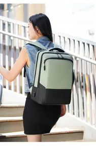 Outdoor shot of a light green and black commuter backpack with a built-in USB charging port