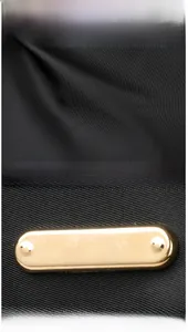 Detailed macro view of premium black woven fabric and glossy gold metal buckle hardware