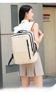 Side view of beige multi-compartment laptop backpack worn by a model in a city setting