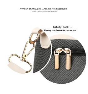 Detailed macro view of glossy gold-plated safety lock and double zippers on the bag