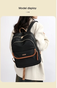 Ergonomic black backpack with brown leather trim and multi-pocket detail on model
