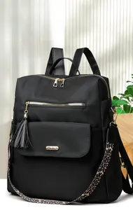 Detail of black nylon backpack with golden zippers and leopard print wide shoulder strap