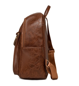 Vue latérale d'un sac à dos vintage en cuir PU marron avec des bretelles texturées