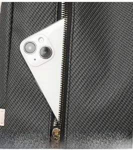 Detail of dark grey woven texture backpack with golden zipper and side storage pocket