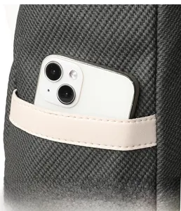 Detail of dark grey woven backpack showing side pocket with a cream leather trim detail