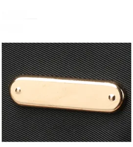 Close-up of black nylon fabric texture with a polished gold metal buckle and rivets