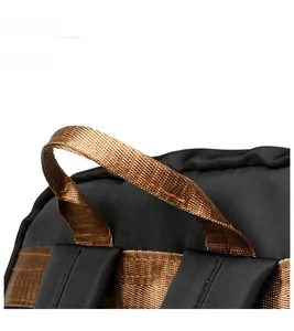 Detail of the high-density bronze handle and black ripstop nylon fabric on the backpack