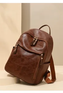 Détail du sac à dos en cuir souple marron foncé avec texture rétro et poches zippées