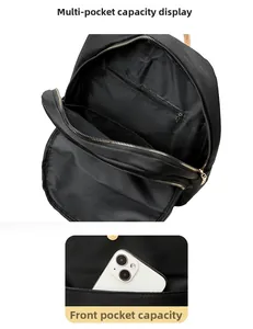 Detail view of multi-compartment interior and front pocket of the black nylon backpack