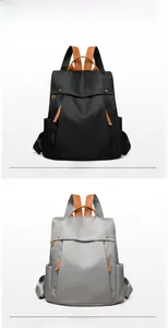 Close-up of waterproof nylon backpacks in black and gray with premium leather trim details