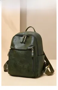 Détail du sac à dos vintage en similicuir vert foncé avec plusieurs poches zippées