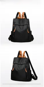 Close-up of waterproof black nylon backpack with brown leather handle and zipper detail