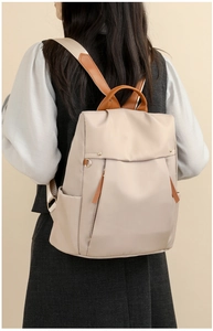 Rear view of a model wearing the large beige canvas laptop backpack with brown leather straps