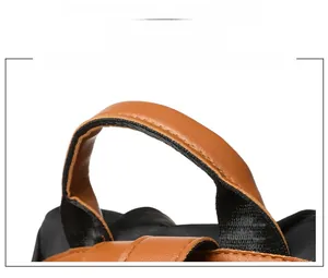 Close-up of ergonomic brown leather handle with durable stitching on canvas backpack