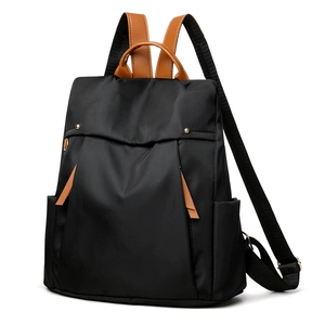 Minimalist black canvas women backpack with brown leather handles and side pockets