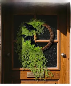 Detail of Halloween door wreath with green plants, crow models, and branch vine ring