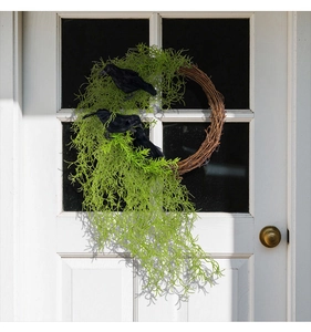 Detail of Halloween crow wreath featuring faux moss and black birds on branch ring
