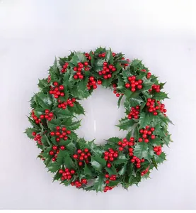 Detailansicht künstlicher Weihnachtskranz mit grünen Stechpalmenblättern und roten Beeren