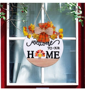 Detail of round wooden welcome sign with turkey graphic and rustic autumn leaf bows
