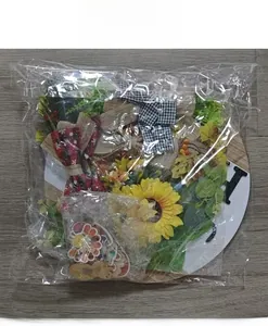 Flat lay of DIY round wooden welcome sign kit with floral decor and bow accessories