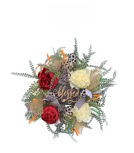 Detail of floral wreath featuring blessed sign, red roses, and striped ribbons