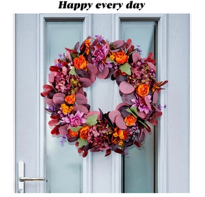 Détail d'une couronne d'automne avec dahlias violets et roses orange sur une porte bleue