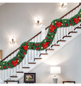 Détail de guirlande de Noël avec poinsettias rouges et boules sur l'escalier