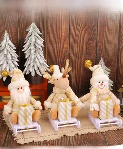 Close-up of Christmas plush dolls in champagne gold and white on wooden sleds