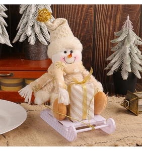 Detail of plush snowman with knit hat on a sled, festive holiday display setup