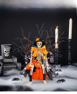 Detailed Halloween skeleton figurine with top hat sitting on pumpkin with gothic decor