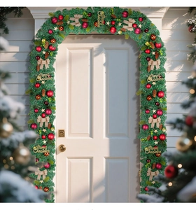 Guirlande de Noël avec pommes de pin, boules rouges et signe Merry Christmas sur une porte