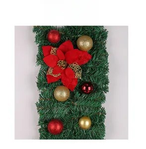 Détail de guirlande de Noël avec aiguilles de pin, fleurs en velours rouge et boules
