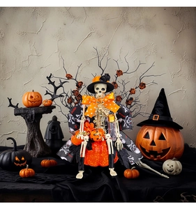 Detail of Halloween skeleton in bow tie sitting on orange pumpkin with spooky accessories