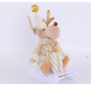Close-up of reindeer plush in knit sweater on a white sleigh with a small gift box