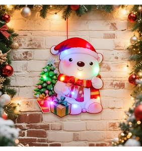 Close-up of LED glowing Christmas door hanger with cute polar bear on a red brick wall
