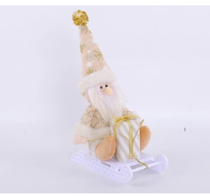 Detail of Christmas gnome with sequined hat and gift box sitting on a white sleigh