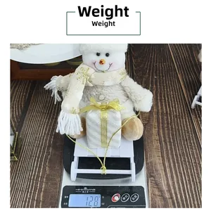 Detailed view of plush Christmas snowman doll on scale weighing 128 grams