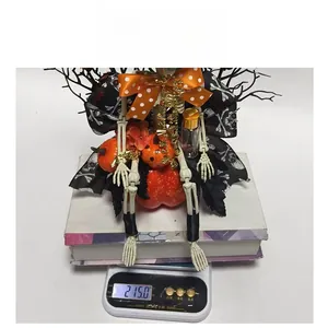 Detail of a Halloween skeleton figure with orange bow tie on scale weighing 215 grams