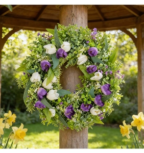 Detalle de tulipanes artificiales morados y blancos con hojas verdes en poste de madera
