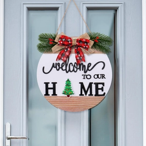 Round wooden Christmas welcome sign with buffalo plaid bow and pine details on grey door
