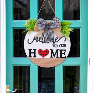 Round wooden welcome sign for front door with green leaves and black white plaid bow decoration