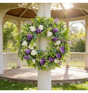 Vista detallada de una corona de tulipanes artificiales violetas y blancos en un jardín