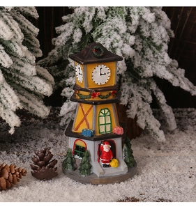 Close-up of a festive Christmas bell tower miniature with Santa Claus in a snowy scene