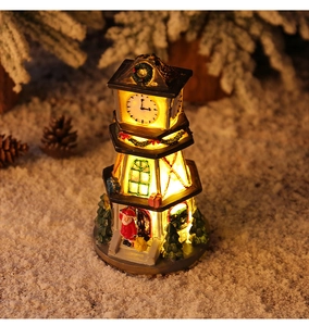 Detail of a lighted Christmas resin clock tower with Santa Claus figurine on snow
